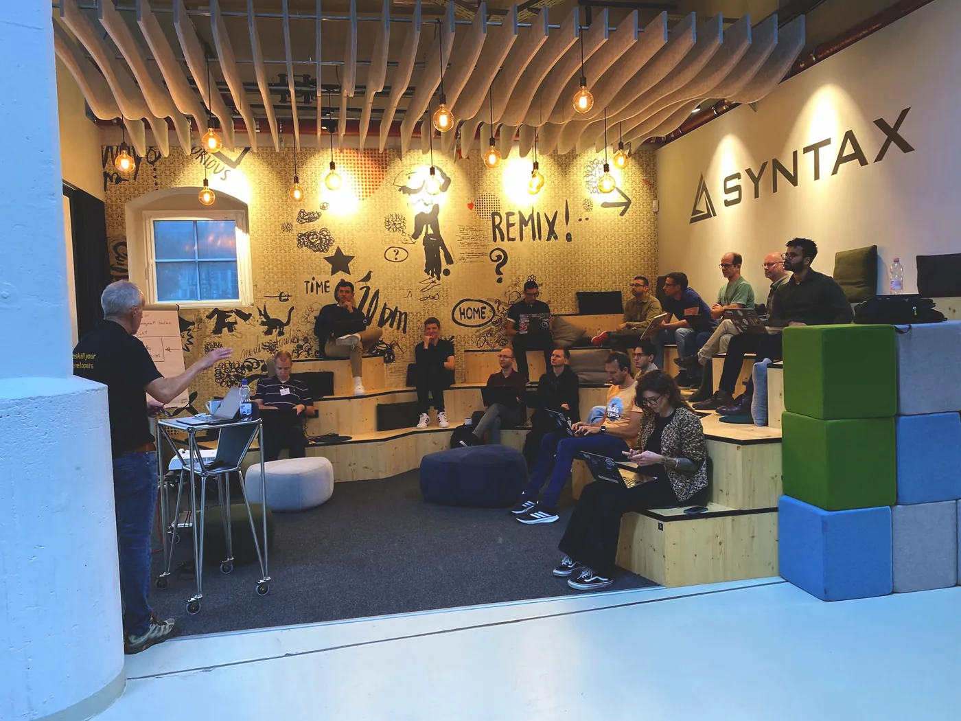 The CodeJam at the Syntax office, participants on the tiered wooden seating with their laptops